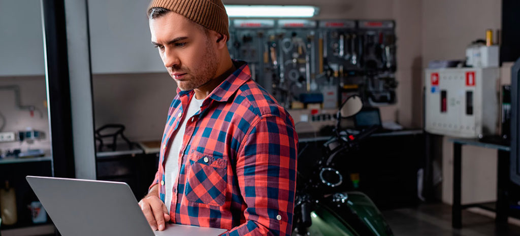 Mecánico de un taller estudiando qué software adquirir para su negocio