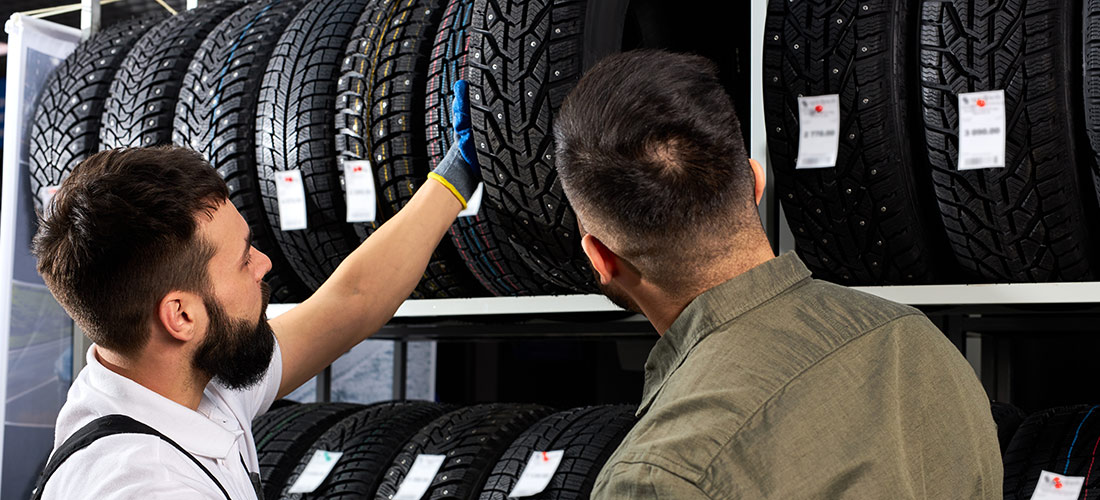 Mecánico aconsejando a un cliente sobre la elección de los neumáticos que debiera elegir para su vehículo