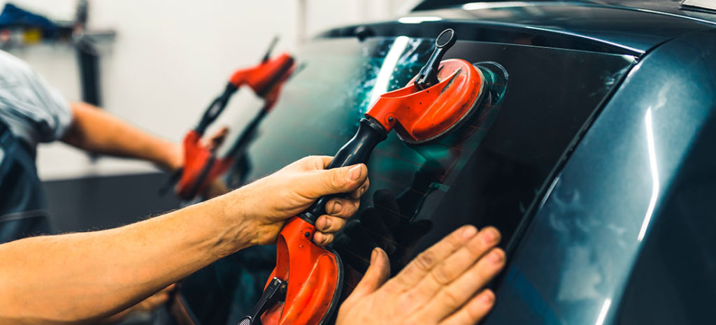 Mecánico instalando la luna de un coche.