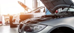 Dos coches con el capó abierto en el taller